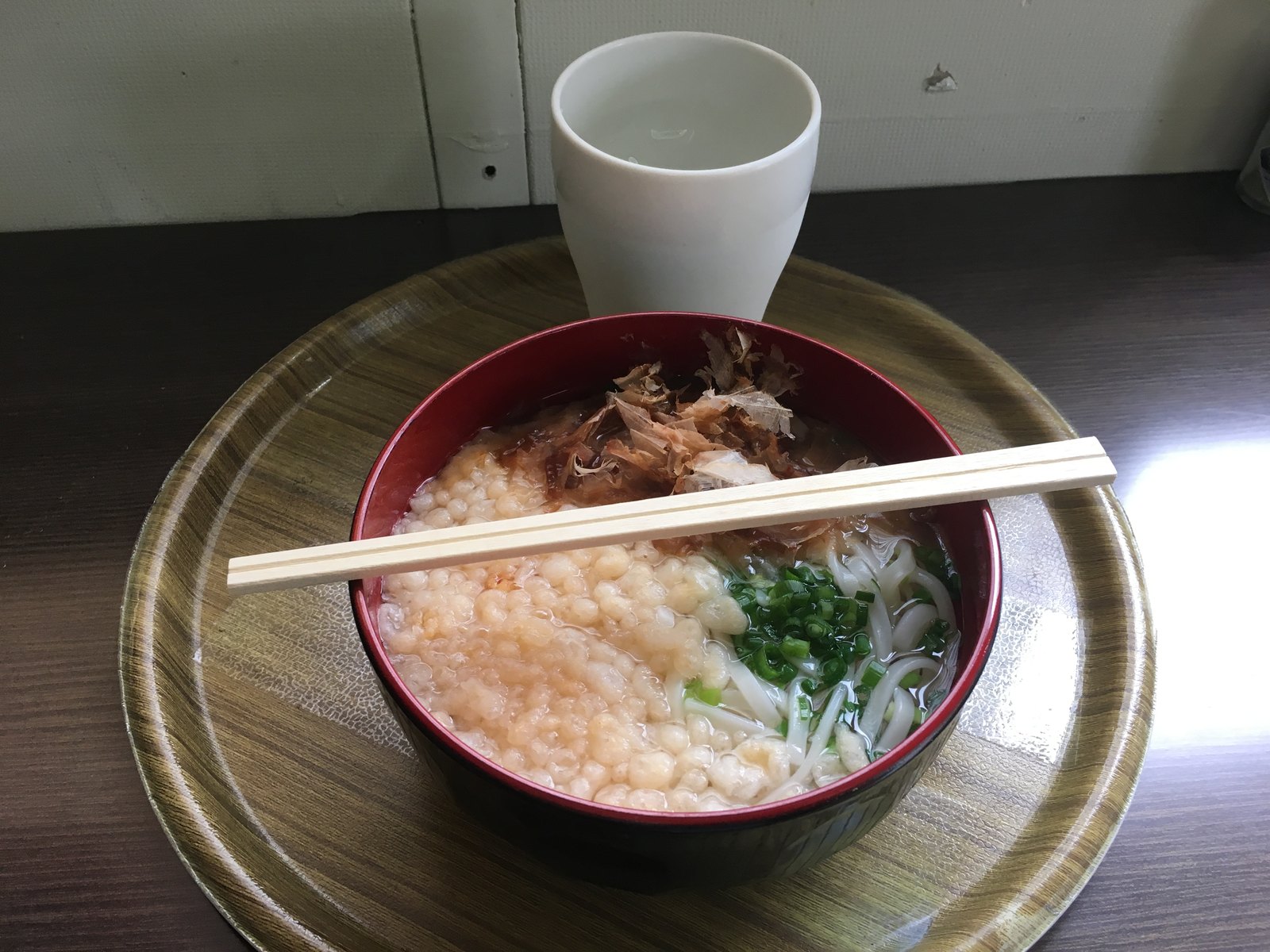 たぬきうどん。透きとおったつゆに天かすと刻みねぎ、削り節がのっている